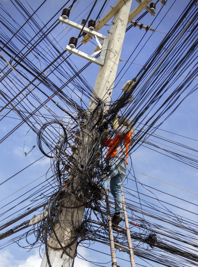 A man trying to work through a tangled mess of wires.